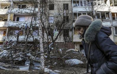 Una mujer pasa por delante de un edificio dañado por los bombardeos en Kiev