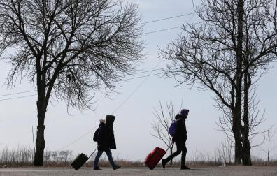 Refugiados caminan por una carretera saliendo de Mariupol