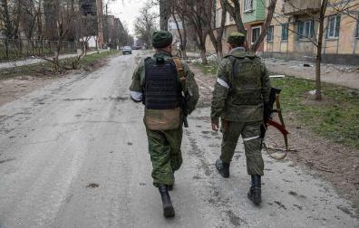 Dos soldados caminan hacia el frente en Mariupol