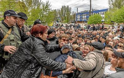 Un amplio grupo de personas espera a recibir ayuda humanitaria en la ciudad ucraniana de Zaporiyia
