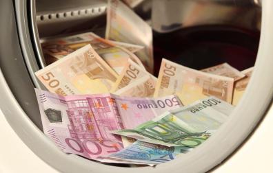 Una lavadora llena de billetes