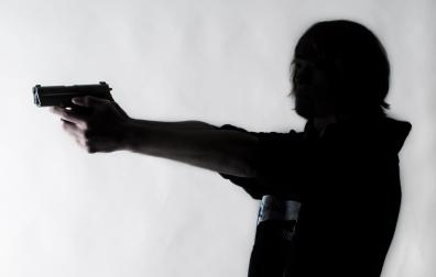 Joven apuntando con un arma