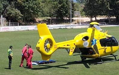 Un agente de la Guardia Civil junto a sanitarios en el césped del campo de fútbol de Miranda de Arga donde aterrizó el helicóptero