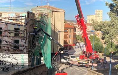 Las grúas tratan de recomponer el andamiaje desprendido del edificio