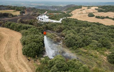 Un helicóptero vierte agua para sofocar el fuego, en un incendio anterior