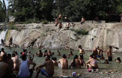 Decenas de personas buscan alivio a las altas temperaturas en el río Arga a su paso por Huarte, especialmente concurrido este domingo a media tarde