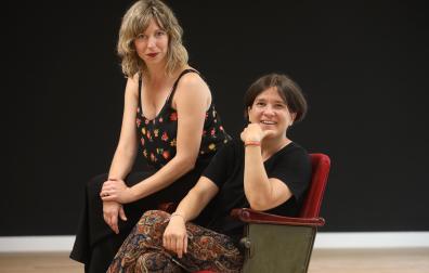 La actriz Leire Ruiz (izq.) y la directora teatral Laura Laiglesia, sentadas en la butaca que da nombre a la escuela de interpretación.