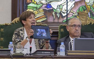 Ana Elizalde (NA+) muestra una foto de Asiron en la calle Curia durante el pleno de ayer