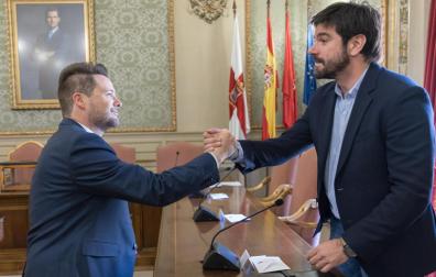 Larrarte, a la izda., da la mano a Alejandro Toquero el día que este último tomó posesión como alcalde