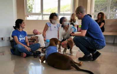Miembros de la asociación Perruneando con un perro y niños en un hospital