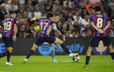 Iago Aspas trata de superar a una barrera de jugadoeres del Barcelona