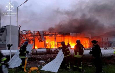 Los bomberos ucranianos trabajan en la extinción de un incendio en un concesionario de coches destruido por los bombardeos en Zaporiyia
