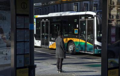 Una persona aguarda en una parada del transporte urbano comarcal.