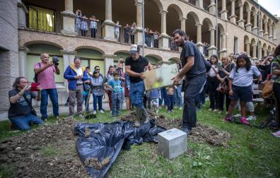 Iosu Zapata, con gorra, introduce la cápsula del tiempo en el jardín del Palacio Ezpeleta