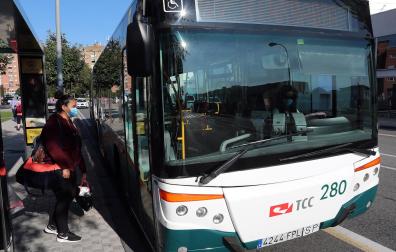 Una persona espera para subir a un autobús en una de las líneas de villavesa en 2020