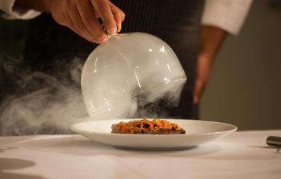 Un camarero sirve un plato en un restaurante