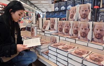 Una mujer ojea el libro de memorias del príncipe Enrique en una librería de Turín (Italia)