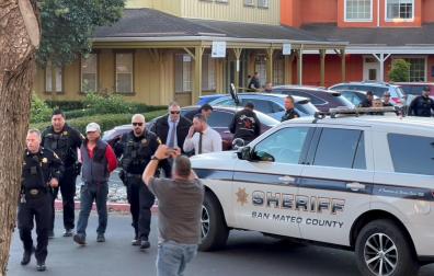 Agentes de la Policía con un hombre detenido tras el tiroteo en Half Moon Bay, en California
