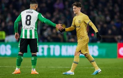 Fekir y Gavi se saludan tras una jugada del partido.