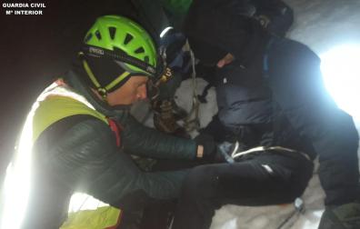 Un agente de la Guardia Civil asegura a uno de los jóvenes durante el rescate