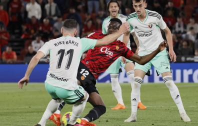Kike Barja trata de impedir que Baba se lleve el balón ante la mirada de Aimar Oroz