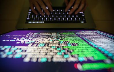 Un experto en informática trabaja en ciberseguridad frente a su pantalla.