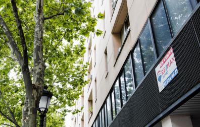 Un cartel de 'En venta' de una inmobiliaria, en un portal del distrito de Embajadores de Madrid