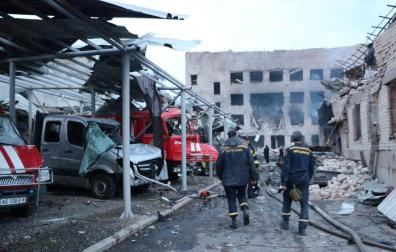 Personal de rescate camina junto a los vehículos destruidos en un complejo de bomberos del Servicio Estatal de Emergencia gravemente dañado por un ataque con misiles rusos, en Dnipro