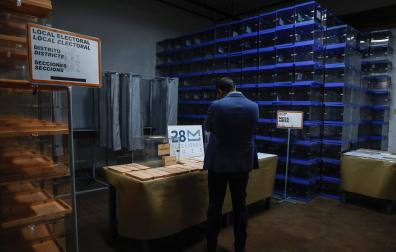 Una persona, junto a papeletas electorales para las próximas elecciones municipales del 28 de mayo