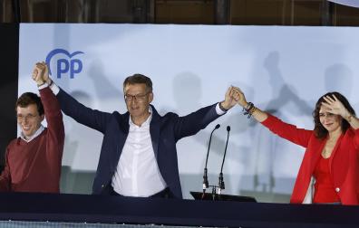 La presidenta de la Comunidad de Madrid y candidata a la reelección por el PP, Isabel Díaz Ayuso (d), el alcalde y candidato a la reelección José Luis Martínez -Almeida (i) y el presidente del partido Alberto Núñez Feijóo (c) saludan a los simpatizantes desde el balcón de Génova tras conocer los resultados electorales en Madrid