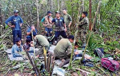 Fotografía cedida por las Fuerzas Militares de Colombia que muestra a soldados e indígenas atendiendo a los niños rescatados tras 40 días en la selva, en Guaviare