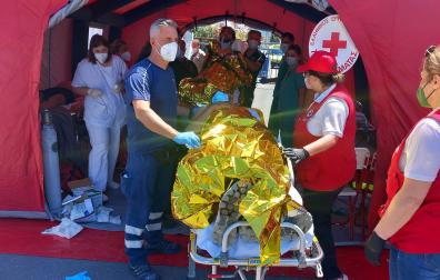 Paramédicos del Servicio Nacional de Ambulancias de Emergencia de Grecia y miembros de la Cruz Roja griega ayudan a migrantes supervivientes del hundimiento de un pesquero en su llegada en el puerto de Kalamata este miércoles.