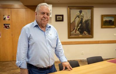 José María Sevilla García, presidente del Club Taurino de Pamplona, ante un cuadro de Rafael de Paula