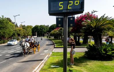 Un coche de caballos pasea por el centro de Sevilla en plena ola de calor, con un termómetro que marca 52 grados