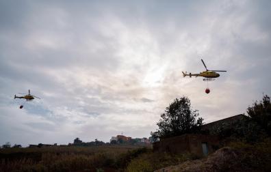 Dos helicópteros sobrevuelan un foco situado en El Ravelo, en el municipio de El Sauzal, una de las zonas afectadas por el incendio forestal declarado el pasado martes en Tenerife.