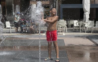 Un niño, refrescándose este martes al mediodía en los chorros de agua de la pamplonesa plaza de Yamaguchi