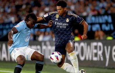 El centrocampista británico del Real Madrid Jude Bellingham (d) lucha con el ghanés Joseph Aidoo, del Celta de Vigo