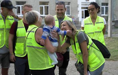 Cristina Ibarrola saluda a un bebé en su visita a Leópilis en 2022