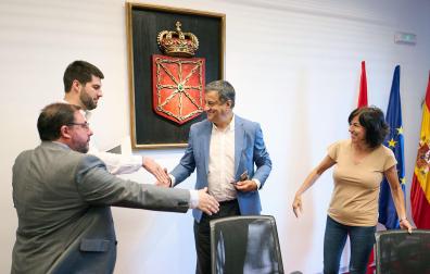 Los parlamentarios se saludan este jueves durante la constitución de una de las comisiones del Parlamento de Navarra