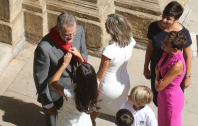 Momento en el que la reina Letizia coloca al rey Felipe VI uno de los pañuelos rojos que unos niños le habían obsequiado en la puerta del Ayuntamiento de Pamplona