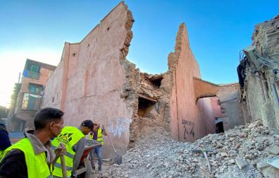 Miembros de los equipos de rescate, junto a un edificio derruido en Marrakech