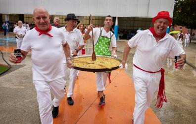 El delicado momento del traslado de una paella XXL a la mesa, en la Comida del Pato de Zizur Mayor