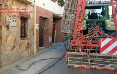 Un tractor arrastra el trenzado de la luz de la fachada de un edificio en Sesma