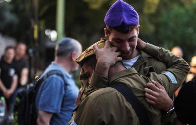 Dos soldados israelíes se abrazan en un funeral en Tel Aviv