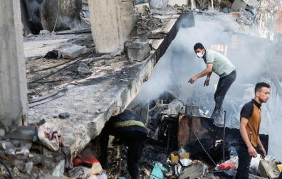 Varias personas buscan supervivientes en un edificio destruido en Khan Younis, al sur de Gaza
