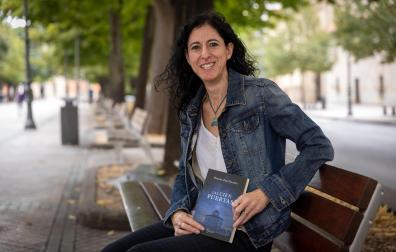 La autora pamplonesa Begoña Pro Uriarte posa este martes por la mañana en el Paseo Sarasate con su última novela, 'Las cien puertas'