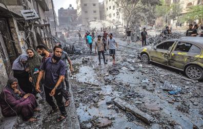 Una familia palestina se lamenta en una calle de la Ciudad de Gaza completamente destruida por los bombardeos de la aviación israelí