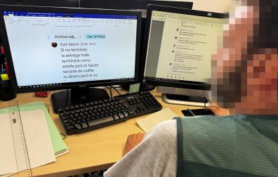 Un agente de la Guardia Civil revisa los mensajes de un caso de estafa del amor