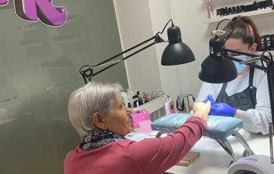 Aránzazu Rodríguez hace la manicura a una clienta en su centro de belleza de la plaza de la Constitución de Burlada