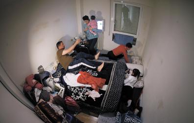 HORA DE DORMIR Todo se amontona en los rincones para poder colocar en el suelo los dos colchones donde duermen los dos hijos mayores, de 11 y 9 años. La bebé, de 6 meses, lo hace con sus padres en la cama de matrimonio. Por la mañana, Fawzi sale de la habitación para trabajar a las 5.30 y su mujer, Zahara, cierra el pestillo por temor.
